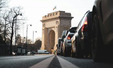 cars on road near brown concrete arch during daytime