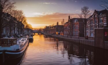 boats on river between buildings