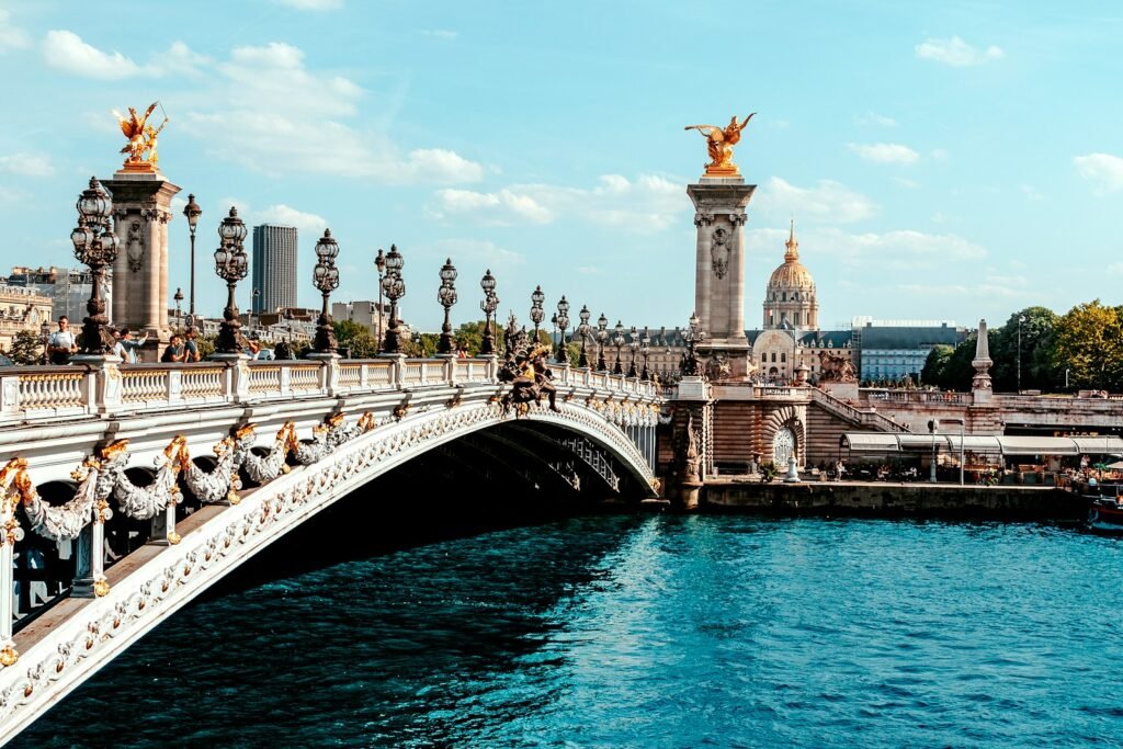 a bridge over a body of water with a statue on top