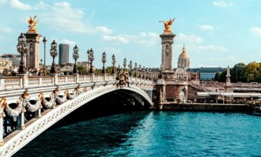 a bridge over a body of water with a statue on top