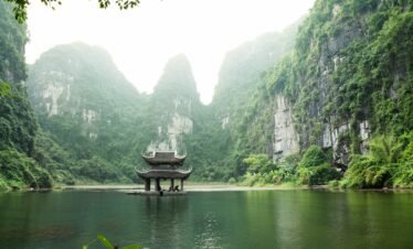 pagoda surrounded by body of water and mountains
