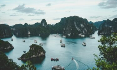 high-angle photography of boats on water near hill during daytime