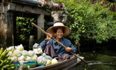A woman in a boat filled with lots of produce