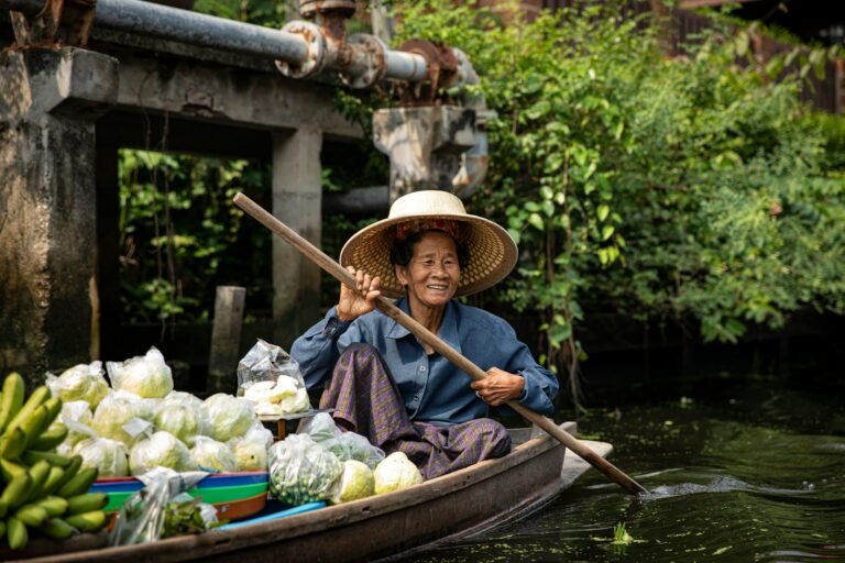 A woman in a boat filled with lots of produce